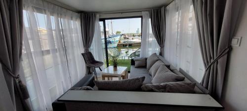 a living room with a couch and a large window at La Mare Resort in Gothenburg