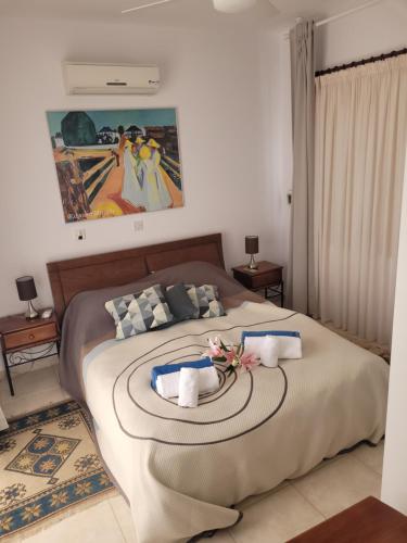 a bedroom with a large bed with a painting on the wall at Hill View Villa 5 in Kouklia