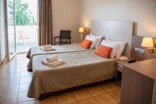 a hotel room with a bed with towels on it at Kalloni Bay in Skala Kallonis