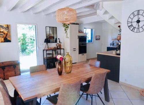 une cuisine et une salle à manger avec une table et des chaises en bois dans l'établissement Maison calme 4 chambres 6 personnes proche mer et Golf La Baule, à Saint-André-des-Eaux