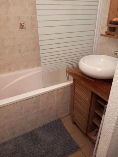 une salle de bain avec un lavabo et une baignoire dans l'établissement Location vacances, à Hourtin
