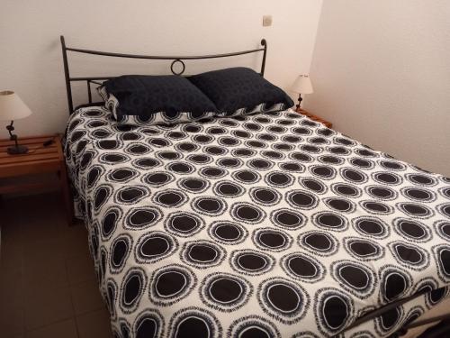 une chambre avec un lit noir et blanc avec deux lampes dans l'établissement Location vacances, à Hourtin