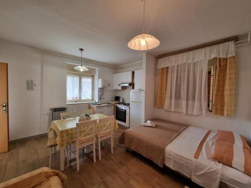 a bedroom with a bed and a table and a kitchen at Apartment Felice in Novigrad Istria