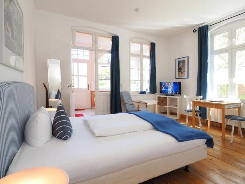 una camera con letto e un soggiorno con scrivania di Villa Dorothea a Heringsdorf