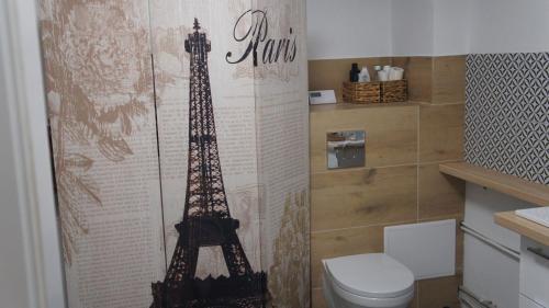 ein Badezimmer mit Toilette und dem Eiffelturm in der Unterkunft Pokoje na Warszawskiej in Gorzów Wielkopolski