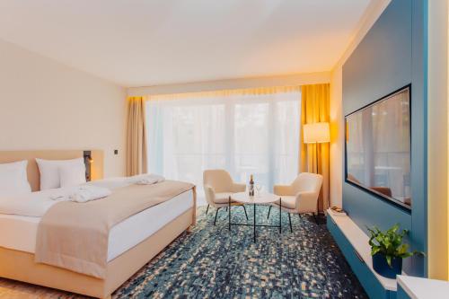 a hotel room with a bed and a table and chairs at Hotel Linea Mare in Pobierowo