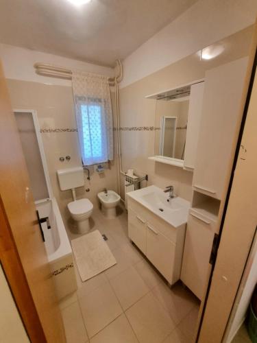 a bathroom with a sink and a toilet and a window at Apartment Felice in Novigrad Istria