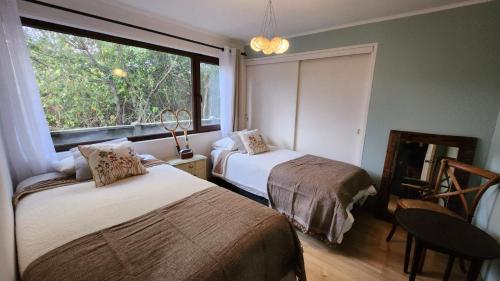 a bedroom with two beds and a window at Cabañas Renova in Valdivia