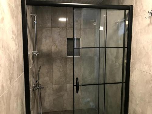 een douche met een glazen deur in de badkamer bij Mavi Villa in Demre
