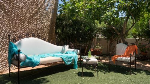 a couch and two chairs in a yard at Beach House Lefkes in Plános