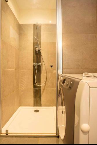 une douche avec une porte vitrée dans une salle de bain dans l'établissement La Grange de Papy, à Vallon-Pont-dʼArc