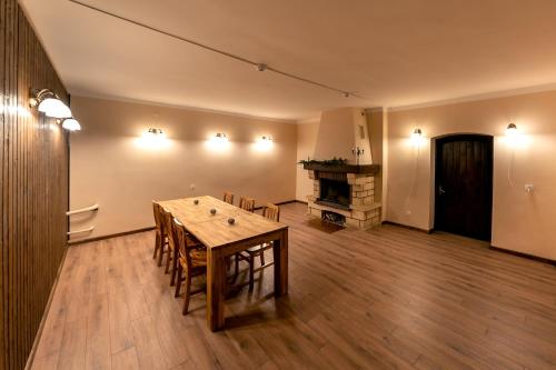 a dining room with a table and a fireplace at Šlokenbekas Muiža in Milzkalne