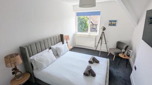 a bedroom with a bed with shoes on it at Sandy Beach Apartment by Seaside Llandudno in Llandudno