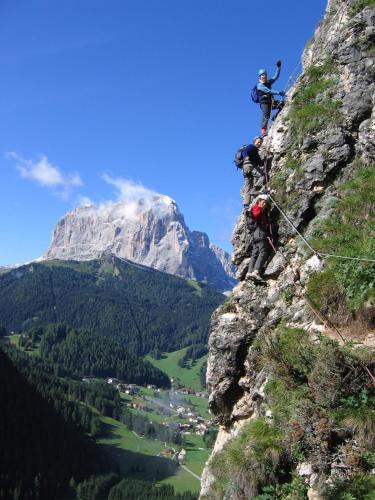 a group of people climbing up a mountain at Garni Hotel Bel Vert in Selva di Val Gardena