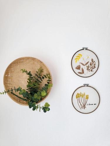 three embroidered plates with plants on a wall at Casa dos Avos by Aqualeisure in Ovar