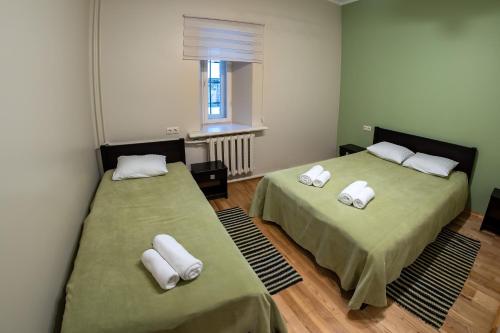 a room with two beds with towels on them at Šlokenbekas Muiža in Milzkalne
