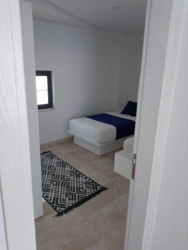 a small bedroom with a bed and a rug at Stone House Aparts 2 plus 1 mit Poolterrasse Kalkan No 2 in Kalkan