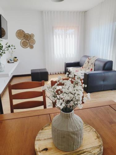 a living room with a vase with flowers on a table at Casa dos Avos by Aqualeisure in Ovar
