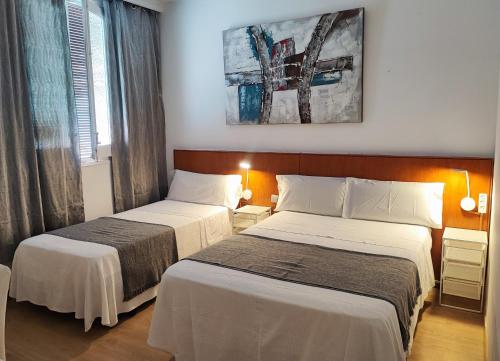 una habitación de hotel con 2 camas y un cuadro en la pared en Hostal Cervantes, en Madrid