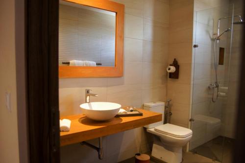 a bathroom with a sink and a toilet and a shower at Nosy Manga - Hotel Ivato Airport in Antananarivo