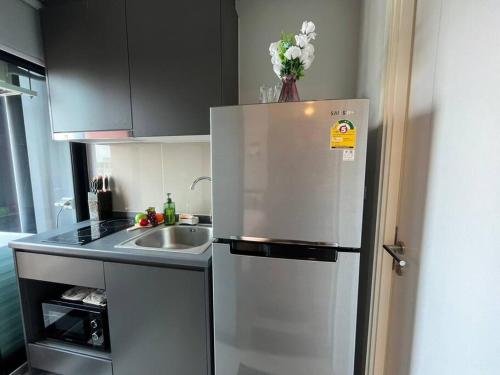 a kitchen with a stainless steel refrigerator and a sink at Monte Rama 9 near JodFair Market Condo in Bangkok