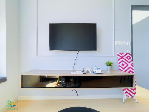 a living room with a tv on a wall at Sunway Grid Residence by RR JBcity in Kampong Pendas
