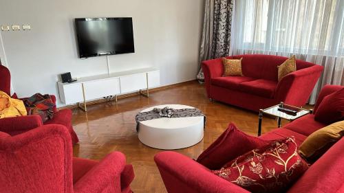 sala de estar con muebles de color rojo y TV de pantalla plana en İstanbul Kadıköy Şenesenevlerde Nezih Metroya Beş Dakika en Estambul