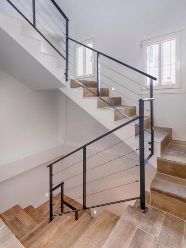 a staircase with glass railings in a house at Hostal Perla Blanca Altea in Altea