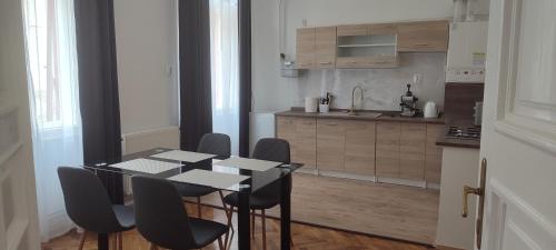 een keuken met een tafel en stoelen in een kamer bij Kriston Apartman 2 in Miskolc