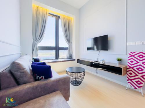 a living room with a couch and a television at Sunway Grid Residence by RR JBcity in Kampong Pendas