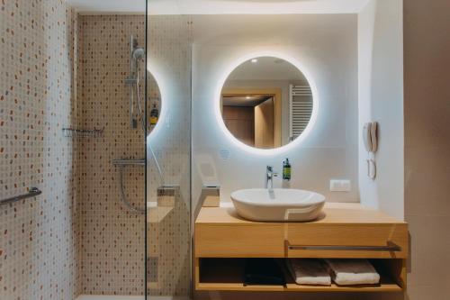 a bathroom with a sink and a mirror at Hotel Linea Mare in Pobierowo