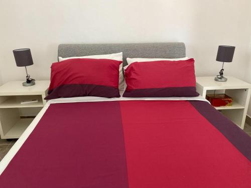 1 cama con sábanas rojas y moradas y 2 mesas en Villa Miran Boka Bay, en Krasići