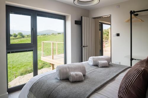 a bedroom with a large bed with a large window at Ty Uchaf Cottage in Llansantffraid Glan Conwy