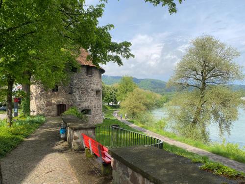 a stone building with benches next to a river at Neues Design-Apartment, Altstadt, Business&Ferien, Küche, Netflix in Bad Säckingen