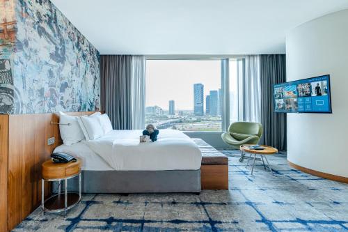 a hotel room with a bed and a large window at Media One Hotel in Dubai