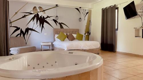 a bath tub in a room with a bed at נופי הבשן - חדרי אירוח מושלמים לזוגות ומשפחות בלהבות הבשן in Lahavot HaBashan