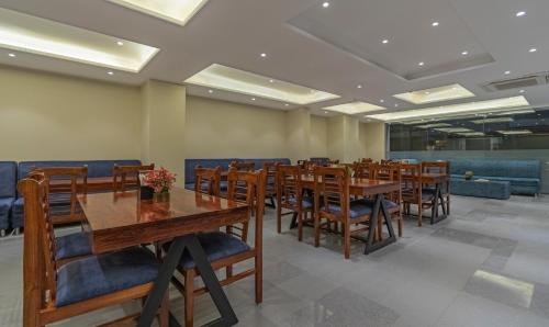 a dining room with wooden tables and chairs at Treebo Pink City Grand in Jaipur
