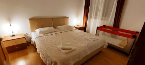 a bedroom with a bed with two towels on it at Apartments Burazer in Šibenik