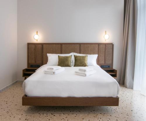 ein Schlafzimmer mit einem großen weißen Bett mit zwei Handtüchern darauf in der Unterkunft Mythodea Athens Suites in Athen