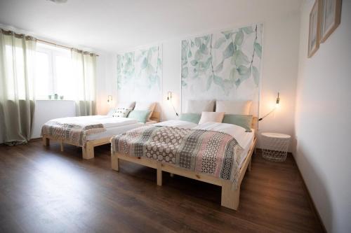 sypialnia z 2 łóżkami i dużym oknem w obiekcie SmartFewo - Das Penthouse - BBQ - Balkon - Parkplatz w mieście Bad Zwischenahn