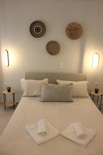 a large white bed with two white towels on it at Théa Apartment in Rethymno