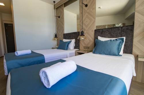 two beds in a room with blue and white at Class Unique Beach in Marmaris