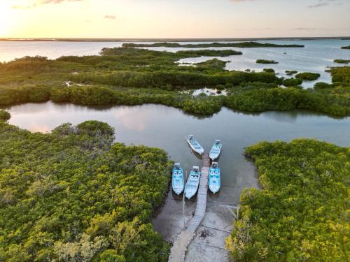 three boats are docked in a harbor in the water at Grand Slam Fishing Lodge Tulum in Punta Allen