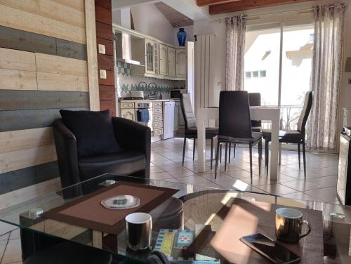 a living room and kitchen with a table and chairs at maisonnette proche gare et plages in Arcachon