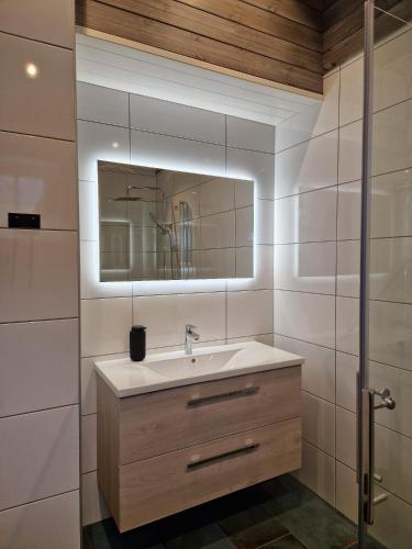 a bathroom with a sink and a mirror at Andøy Vest Rorbuer Reine in Reine