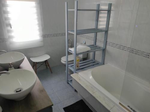 łazienka z umywalką, toaletą i wanną w obiekcie Fogar San Sadurniño w mieście Cambados