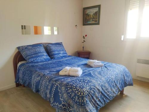 a bedroom with a blue bed with towels on it at ZOLA T2 calme et équipé limitrophe de Lyon avec le métro à 3min in Villeurbanne