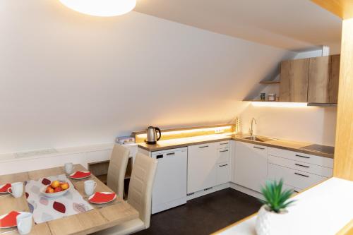 a kitchen with white cabinets and a table with fruits on it at Haus Rosy Ferienwohnung in Stubenberg