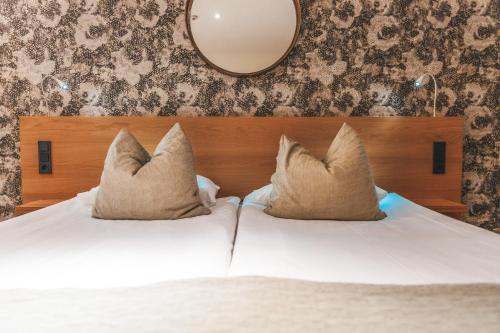 a bedroom with a white bed with pillows and a mirror at Sankt Jörgen Park in Gothenburg