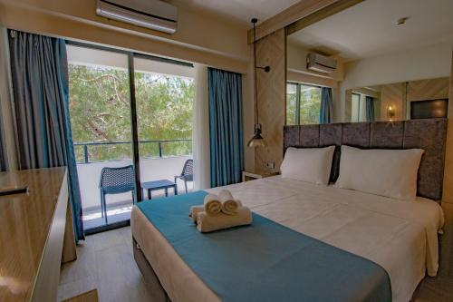 a bedroom with a large bed with a towel on it at Class Unique Beach in Marmaris